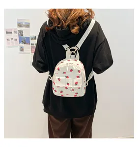 Cute white corduroy mini backpack with red strawberry print, perfect for daily casual use.