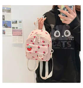 Pink corduroy mini backpack with cute strawberry print detail, casual school style bag.