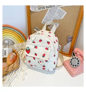 Cute strawberry print corduroy backpack detail shot, aesthetic small school bag for daily use.