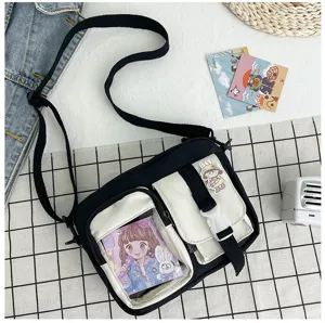 Sac bandoulière en toile noire avec une poche transparente et des autocollants anime.