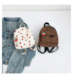 Detail shot of cute corduroy mini backpacks with strawberry print, casual daily school bags.