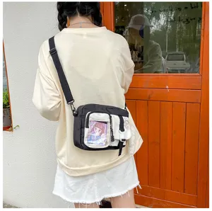 Sac à bandoulière en toile noir et blanc pour femme, style décontracté avec poche transparente.