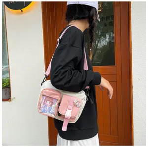 Vue détaillée du sac bandoulière en toile avec une poche avant transparente et élégante.