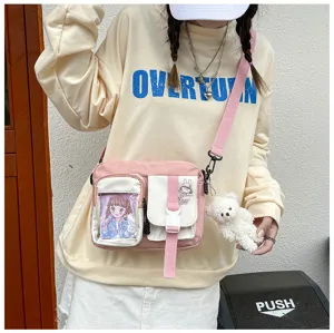 Sac bandoulière en toile rose pour femme avec poche transparente et pendentif en peluche.