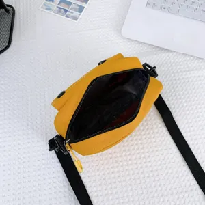 Yellow canvas crossbody bag for women, trendy casual messenger bag with black shoulder strap.
