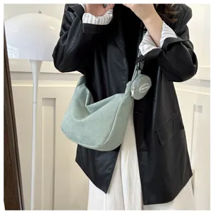 Detail view of light green corduroy shoulder bag with mini coin pouch and smooth zipper.