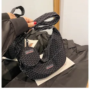 Canvas dumpling crossbody bag detail showing black white pattern and mini round pouch.