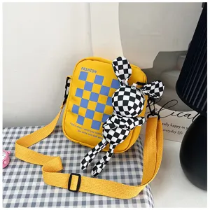 Detailed view of the yellow colorblock canvas crossbody bag with cute checkered rabbit pendant.