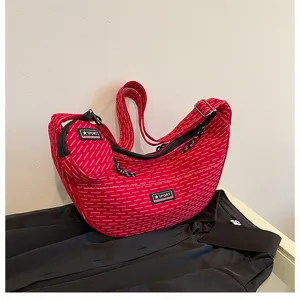 Detail view of red canvas dumpling crossbody bag with small pouch and casual strap.
