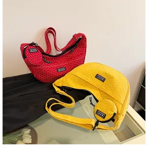 Detailed view of casual canvas crescent crossbody bags with small coin purses in bright colors.
