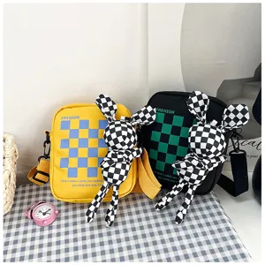 Fashion checkerboard canvas crossbody bag with cute rabbit plush pendant for students.