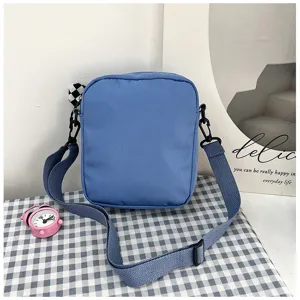 Close-up detail of the stylish blue canvas crossbody bag with adjustable strap and hardware.