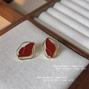 Orecchini a lobo in metallo smaltato bordeaux rétro, eleganti dettagli geometrici dorati.