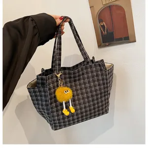 Black and white plaid tote bag with cute yellow plush monster keychain, casual large capacity.