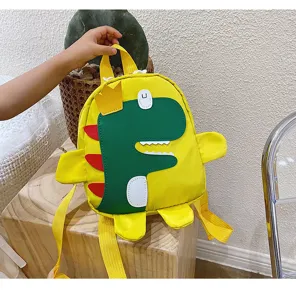 Detailed view of cute cartoon dinosaur children backpack in bright yellow and green fabric.