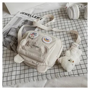 Cute nylon crossbody bag for women, casual white shoulder bag with cute bear ears and pendant.