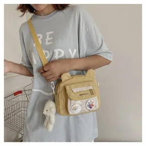 Cute nylon crossbody bag detail, sweet bear ears design, transparent front pocket and charms.