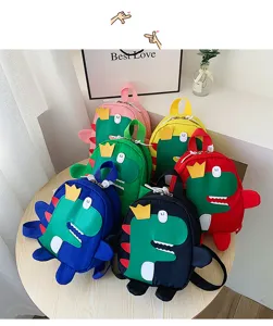 Close-up details of multi-color cute cartoon dinosaur backpacks displayed on wooden table.