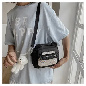 Cute nylon bear crossbody bag detail showing transparent pocket, soft pendant and strap.