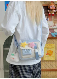 Detailed view of the cute light blue cross-body bag with fluffy star charms and sweet style.