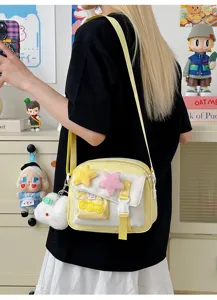Cute casual canvas crossbody bag for women with plush star charms and front pocket details.