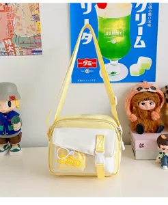 Cute yellow and white canvas crossbody bag detail showing front pocket and buckle design.