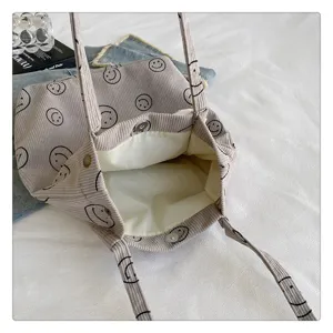 Corduroy tote bag detail showing cute black smiley faces print and inner magnetic snap closure.