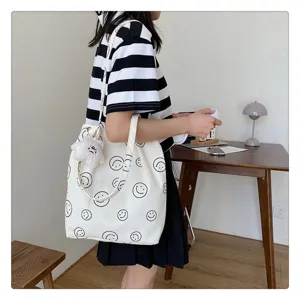 Detailed scene view of the casual canvas tote bag featuring cute smiley face prints and plush charm.