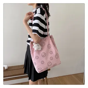 Casual pink corduroy tote bag with cute smiley faces and fluffy charm for daily use.