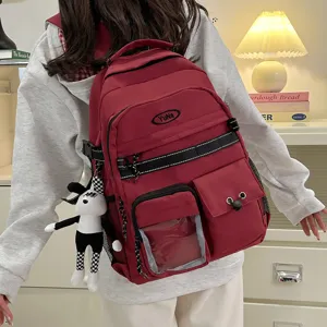 Casual canvas school backpack with multiple pockets and cute doll pendant for daily use.