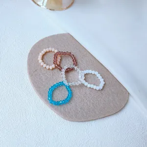Close-up detail of colorful beaded elastic rings set, stylish and minimalist everyday jewelry accessories.