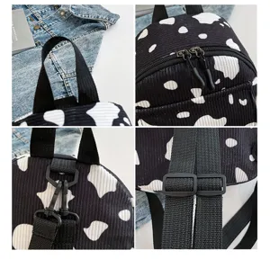 Kord schwarz weiß Kuhmuster Rucksack Detail mit Reißverschluss und verstellbaren Trägern.