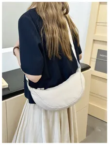 Detailed view of white crescent shoulder bag, casual everyday fashion accessory style.