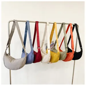 Detailed view of casual nylon crescent shoulder bags hanging on rack in multiple vibrant colors.