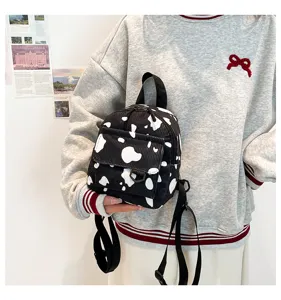 Detailansicht des stylischen schwarz-weißen Kuh-Print Cord Mini-Rucksacks für den Alltag.