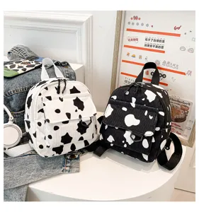 Modischer Mini-Rucksack aus Kord mit schickem Kuhmuster in Schwarz-Weiß, lässige Tasche.