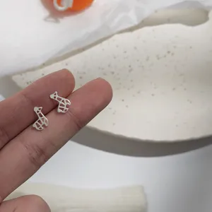 Nahaufnahme von Mini Giraffen Ohrsteckern, zartes silberfarbenes Design für den Alltag.
