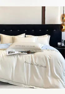 Detalle de juego de cama de algodón bordado de lujo, funda nórdica suave con escritura elegante.