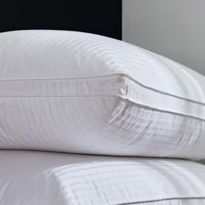 Close-up detail shot of luxury white striped hotel pillow, three-layer quilted cotton design.