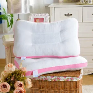 Gedetailleerd overzicht van het ergonomische witte nekcussentje met roze rand in interieur.