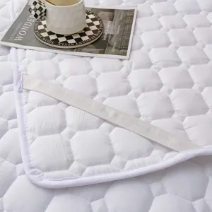 Dettaglio coprimaterasso trapuntato bianco, fodera imbottita spessa con fascia elastica.