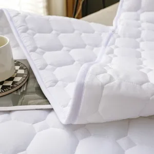 Dettaglio coprimaterasso trapuntato, fodera letto in cotone bianco spesso primo piano.