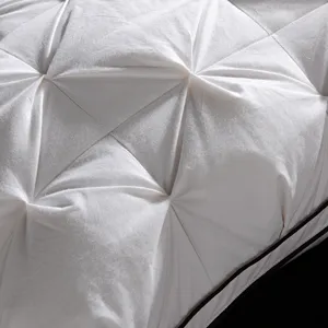 Detailed close-up shot of a white cotton down pillow with elegant pinch-pleat texture.
