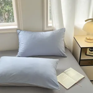 Minimalistische effen katoenen kussenslopen en beddengoedset voor een gezellige slaapkamer.