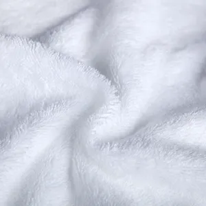 Primer plano detallado de una toalla de algodón blanco suave con bucles densos y esponjosos.