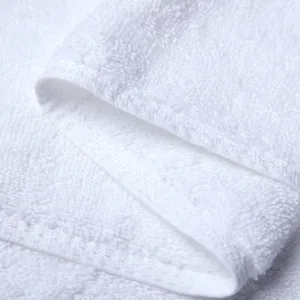 Primer plano detallado de toalla de hotel de algodon blanco con textura suave.