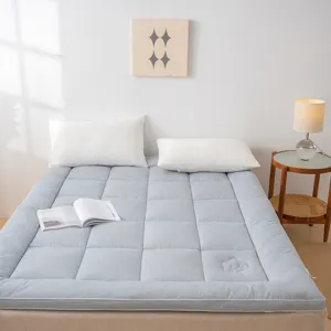 Vue détaillée du matelas doux à carreaux bleus, rembourrage en coton confortable pour lit.