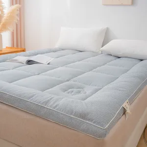 Gros plan sur le surmatelas à carreaux bleu et blanc épais, texture de grille confortable.