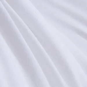 Gedetailleerd overzicht van zachte witte katoenen stof met fijne textuur en natuurlijke plooien.