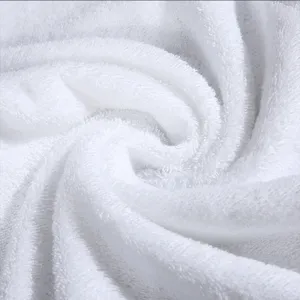 Detailed close-up of soft white cotton towel fabric showing plush texture and loop weave.